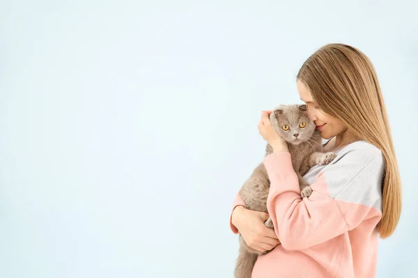 Beautiful woman with cute cat on color background — Stock Photo, Image