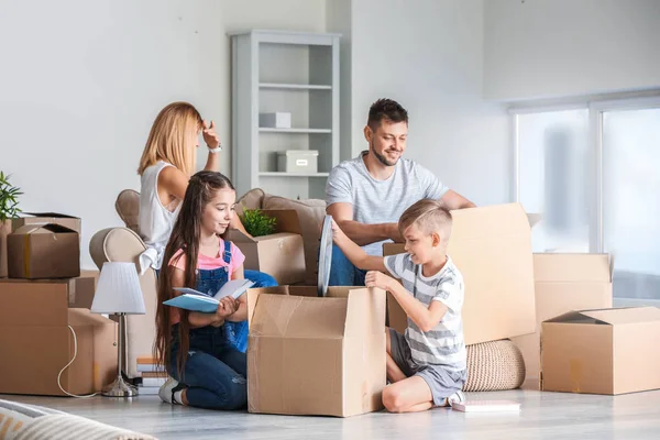 Família feliz desempacotando pertences em sua nova casa — Fotografia de Stock