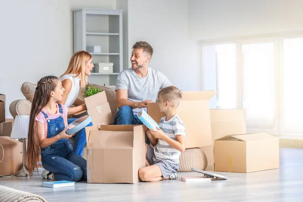 Happy family unpacking belongings in their new house — Stock Photo, Image