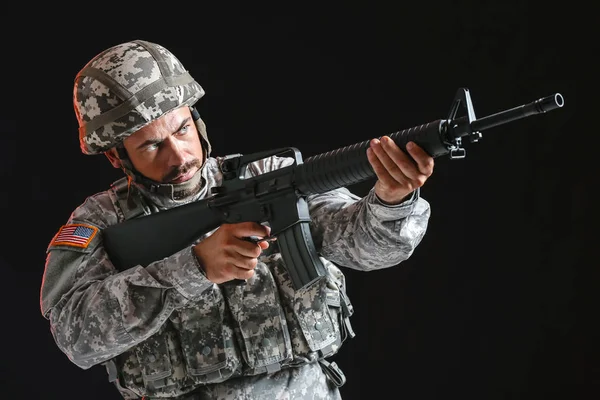 Soldado em camuflagem apontando para fundo escuro — Fotografia de Stock