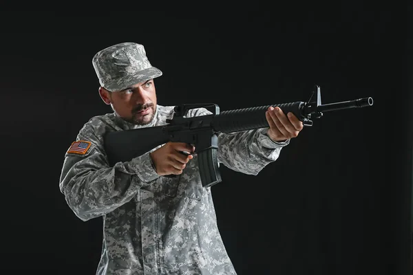 Soldado em camuflagem apontando para fundo escuro — Fotografia de Stock