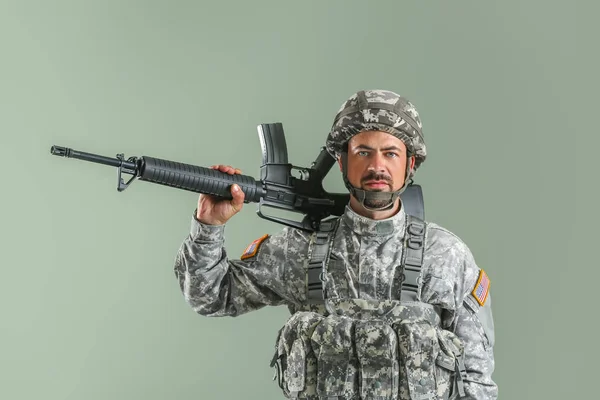 Soldier with assault rifle on color background — Stock Photo, Image