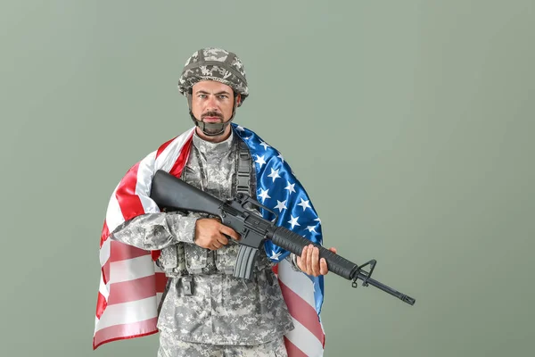 Żołnierz z Narodową flagą USA i karabin szturmowy na kolorowym tle — Zdjęcie stockowe