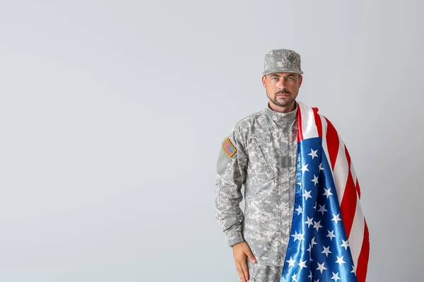 Soldado con bandera nacional de Estados Unidos sobre fondo claro — Foto de Stock