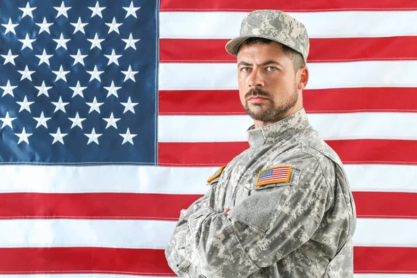 Soldier in camouflage with national flag of USA on background — Stock Photo, Image