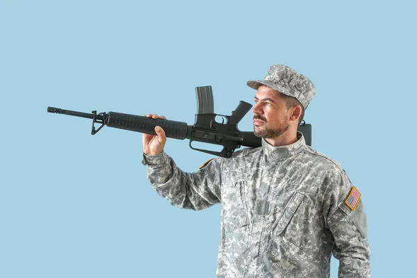 Soldier with assault rifle on color background — Stock Photo, Image