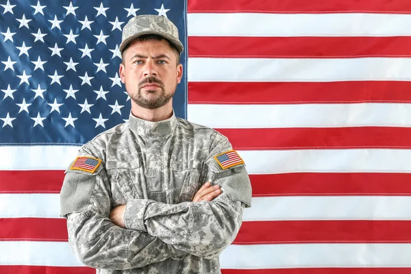 Soldier in camouflage with national flag of USA on background — Stock Photo, Image