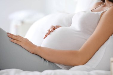 Güzel genç hamile kadın yatak odasında