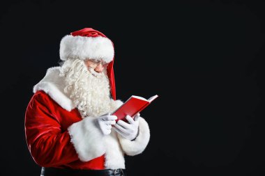 Santa Claus karanlık arka plan üzerinde kitap ile