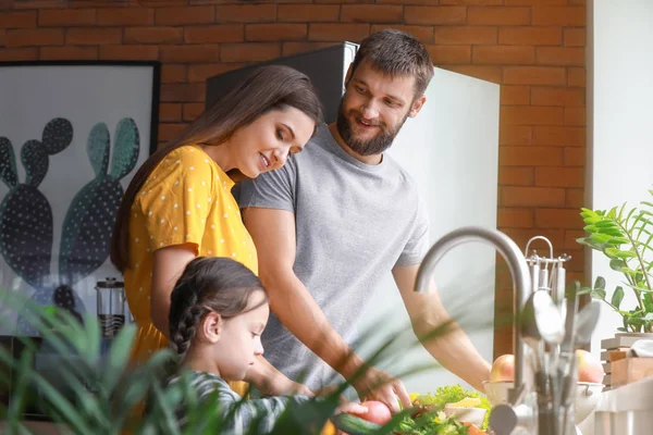 Jovem família cozinhar juntos na cozinha — Fotografia de Stock