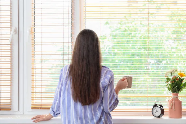 Mañana de hermosa joven bebiendo café cerca de la ventana — Foto de Stock