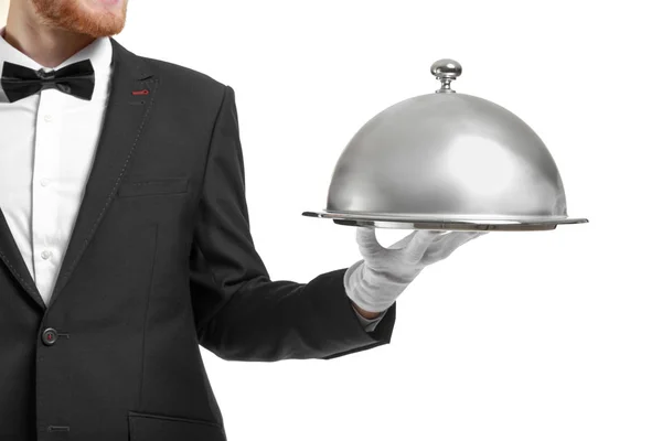 Knappe kelner met lade en cloche op witte achtergrond — Stockfoto