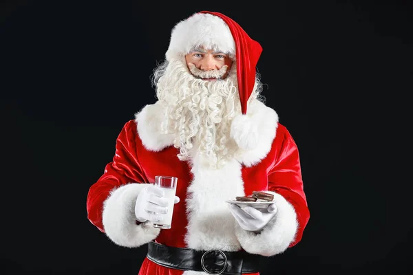 Babbo Natale con latte e biscotti su sfondo scuro — Foto Stock