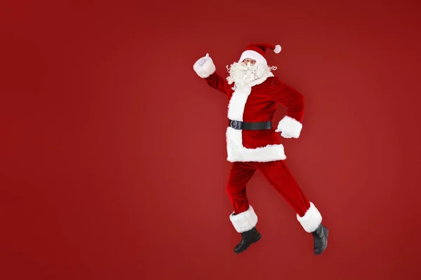 Portrait of jumping Santa Claus on color background — Stock Photo, Image