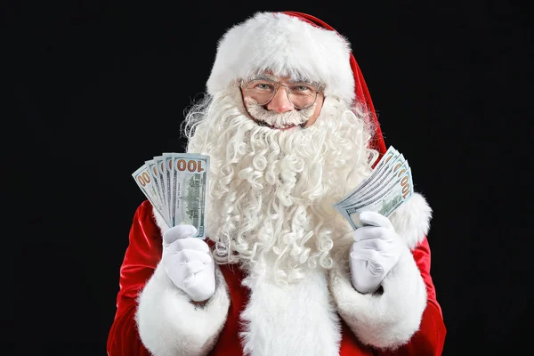 Санта-Клаус с деньгами на темном фоне — стоковое фото