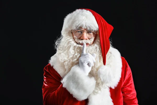 Retrato de Papai Noel mostrando gesto de silêncio sobre fundo escuro — Fotografia de Stock