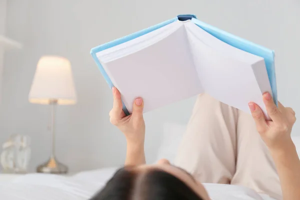 Hermosa joven leyendo libro en el dormitorio — Foto de Stock