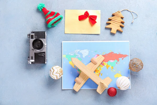 Composizione con mappa, macchina fotografica, aereo e decorazioni natalizie su sfondo a colori — Foto Stock