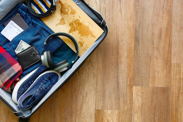 Βαλίτσα με αντρικά ρούχα, αξεσουάρ και χάρτη σε ξύλινο φόντο — Φωτογραφία Αρχείου