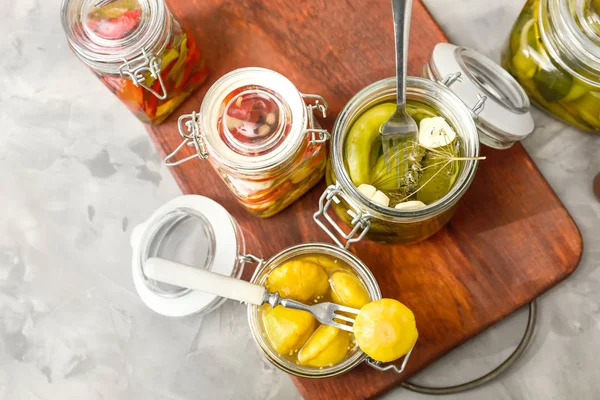 Frascos com diferentes vegetais enlatados na mesa — Fotografia de Stock