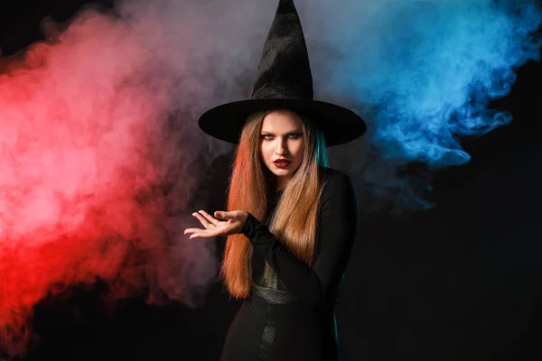 Hermosa mujer vestida de bruja para Halloween sobre fondo oscuro — Foto de Stock