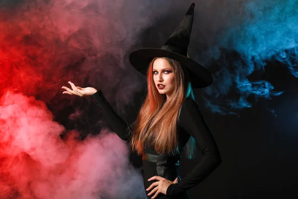 Mooie vrouw verkleed als heks voor Halloween op donkere achtergrond — Stockfoto