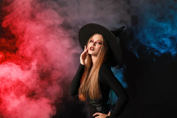 Belle femme habillée en sorcière pour Halloween sur fond sombre — Photo