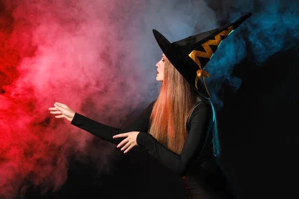 Красива жінка, одягнена як відьма для Хеллоуїна на темному тлі — стокове фото