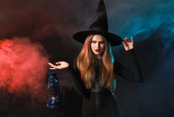 Mulher bonita vestida como bruxa para o Halloween no fundo escuro — Fotografia de Stock