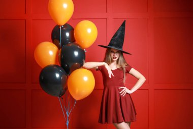 Cadı olarak Cadılar Bayramı için renk arka plan üzerinde giymiş kadın güzel