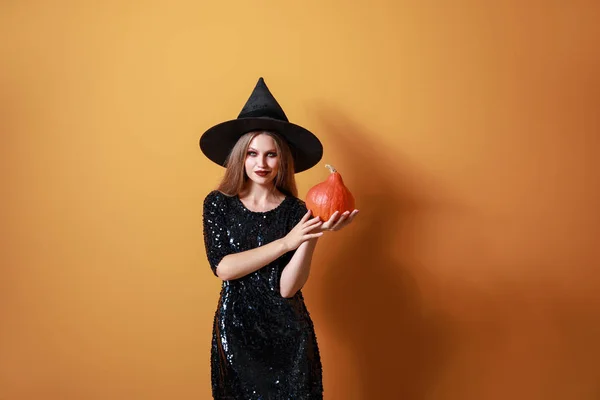 Gyönyörű nő öltözött boszorkány Halloween színben háttér — Stock Fotó