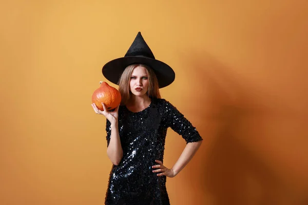 Beautiful woman dressed as witch for Halloween on color background — Stock Photo, Image