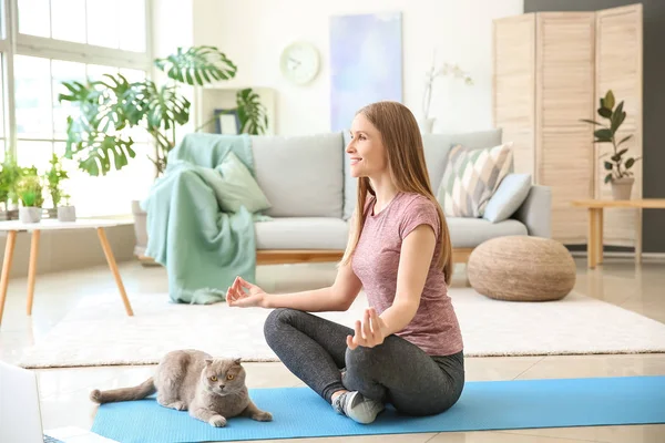 Mulher bonita com gato bonito meditando em casa — Fotografia de Stock