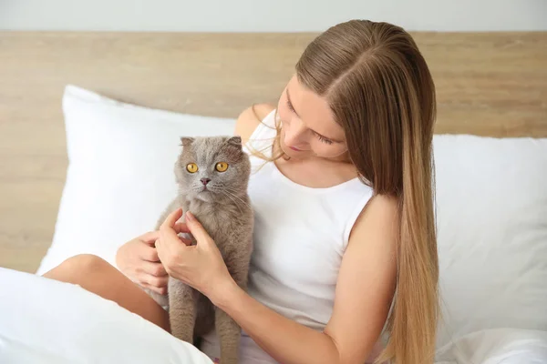 Evde yatakta oturan sevimli kedi ile güzel kadın — Stok fotoğraf