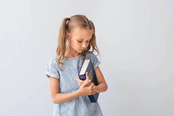 Hafif arka plan Üzerinde İncil ile Sevimli küçük kız — Stok fotoğraf
