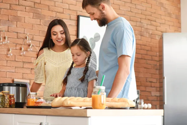Familia joven con bollos recién horneados en la cocina —  Fotos de Stock