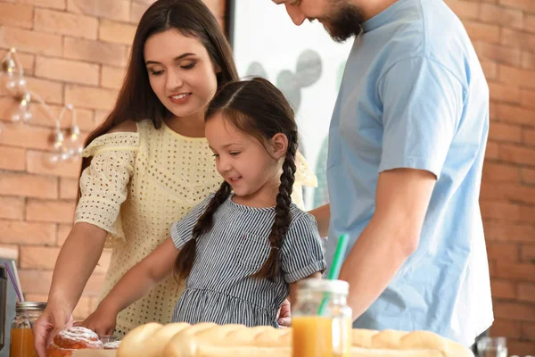 Young family with freshly baked buns in kitchen — Stock Photo, Image