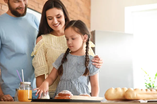 Young family with freshly baked buns in kitchen — Stock Photo, Image