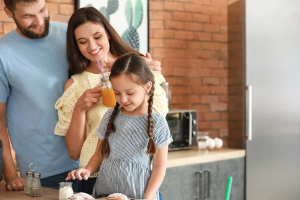 Young family with freshly baked buns in kitchen — Stock Photo, Image