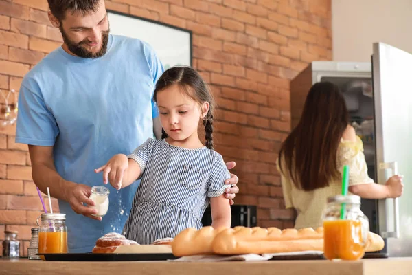 Young family with freshly baked buns in kitchen — Stock Photo, Image