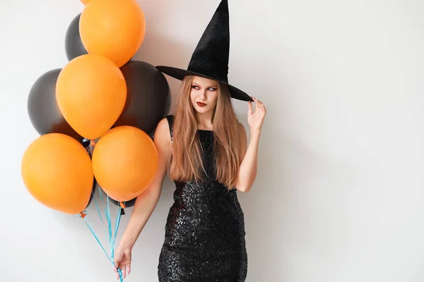 Belle femme habillée en sorcière pour Halloween sur fond clair — Photo