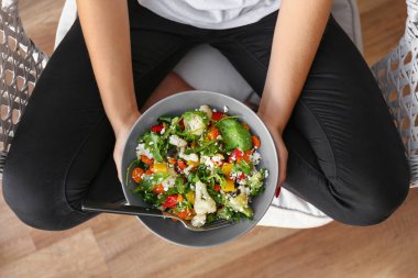 Kadın taze salata ile kase tutan, üst görünümü