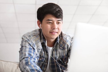 Dizüstü bilgisayar ile Asyalı öğrenci evde sınava hazırlanıyor