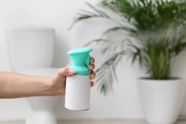 Woman spraying air freshener in bathroom — Stock Photo, Image