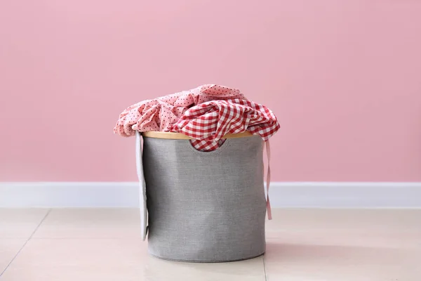Basket with laundry on floor near color wall — Stock Photo, Image