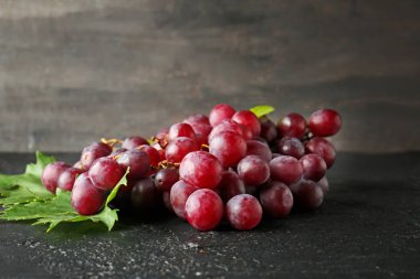 Ripe sweet grapes on dark table clipart