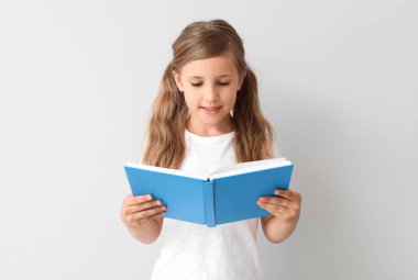 Hafif arka plan üzerinde kitap ile küçük kız