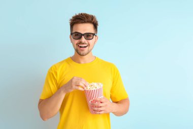 Hafif arka planda film izlerken patlamış mısır ile genç adam