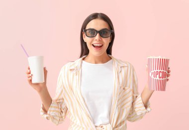 Patlamış mısır ve içki renkli arka planda film izlerken genç kadın