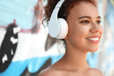 Güzel Afrikalı-Amerikalı kadın açık havada müzik dinliyor